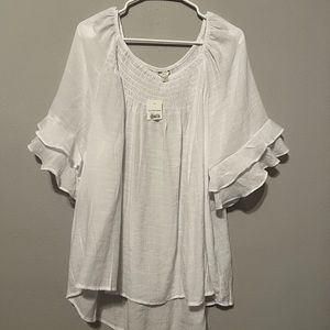 White blouse with bell sleeves. It’s made of a thin, cool material.